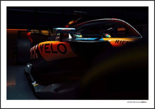 Plagát Lando Norris jazdiaci v monoposte McLaren F1, zachytený v akcii s moderným dizajnom a energickým pozadím.
