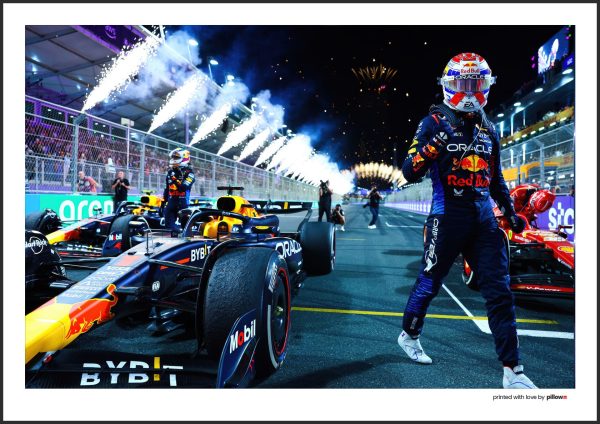 Dynamický plagát Maxa Verstappena v nočnej atmosfére pitlane, zdôrazňujúci vzrušenie a napätie pred štartom pretekov F1.