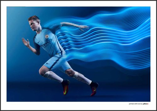 Futbalový plagát Kevina De Bruyneho v drese Manchester City, zachytávajúci jeho sústredený pohľad a majstrovské ovládanie lopty.